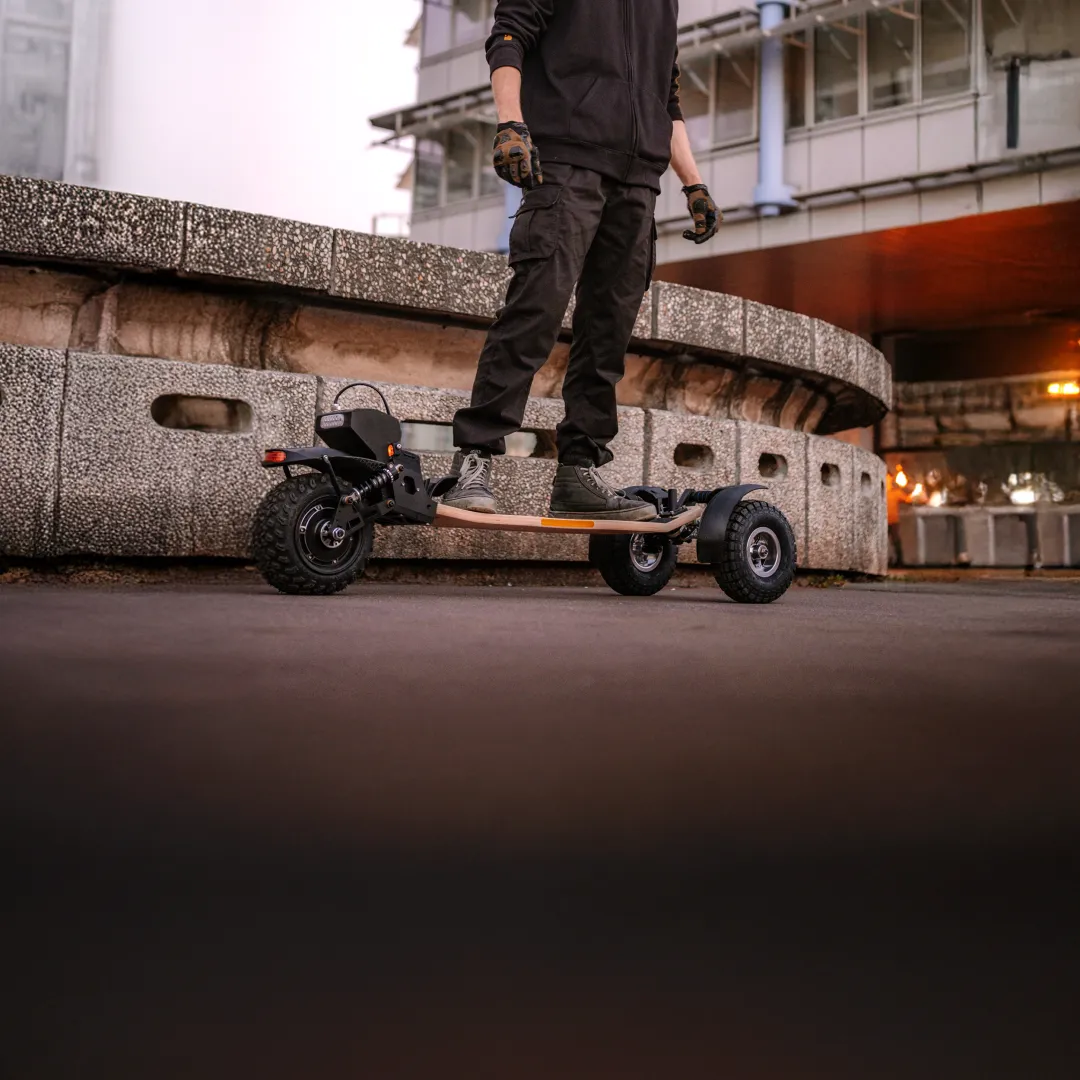 Rider Sternboard en milieu urbain contemporain de nuit avec skateboard électrique trois roues