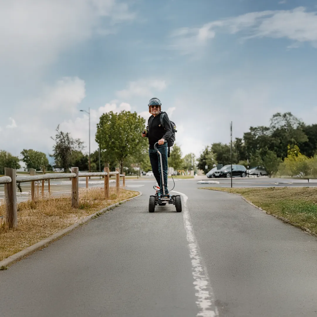 Rider senior souriant sur Sternboard électrique tout-terrain, démonstration de facilité d'usage et accessibilité multigénérationnelle pour débutants en sports de glisse