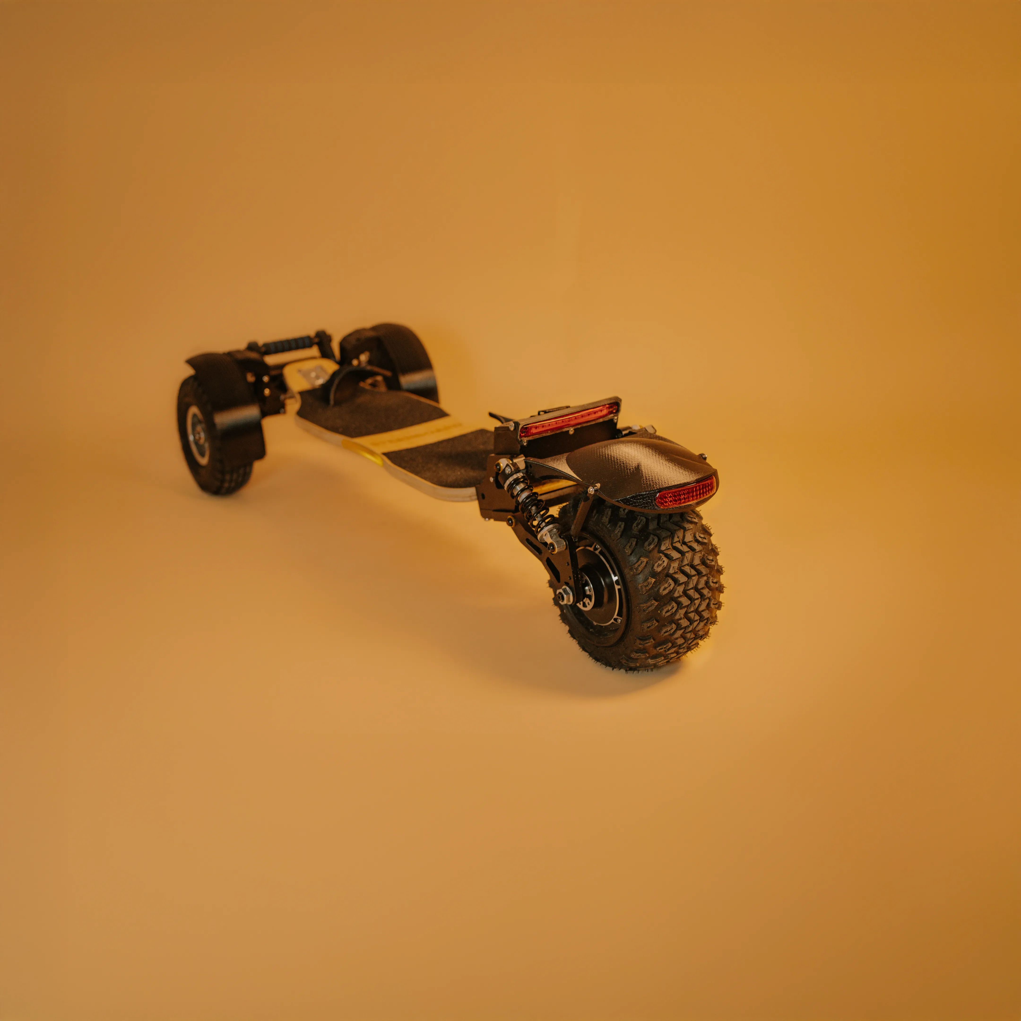 Vue complète skateboard électrique Sternboard avec garde-boue trois roues et éclairage LED arrière.