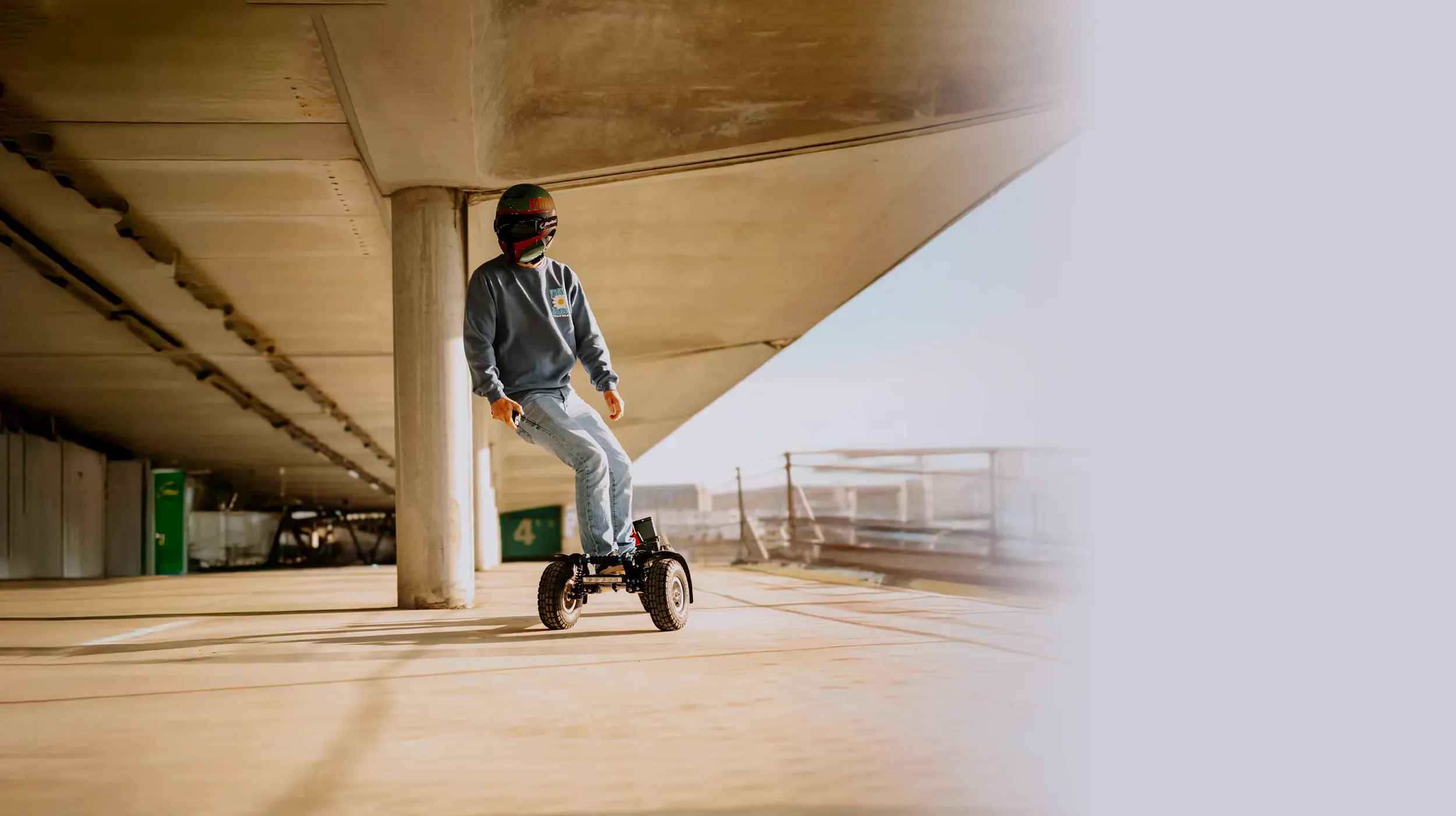 Rider en action sur Sternboard skateboard électrique 3 roues dans parking souterrain moderne avec casque et sac à do